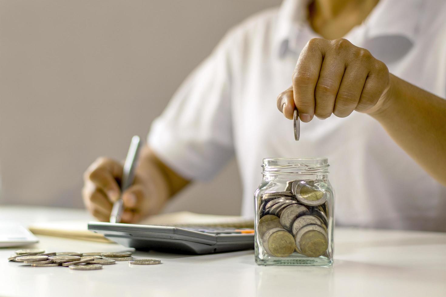 Une personne qui met de l'argent dans une jar.