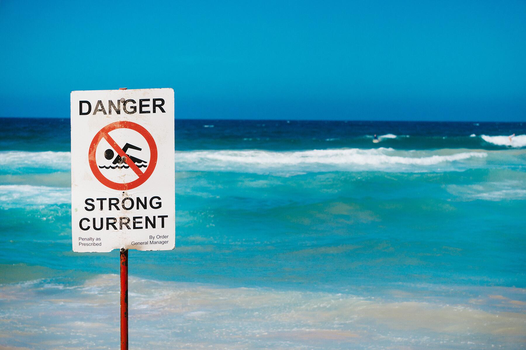 Une plage avec un panneau danger